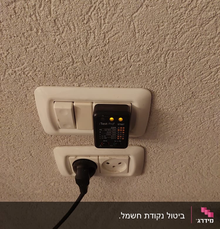 בודק חשמל מחובר לשקע עם נורות דולקות